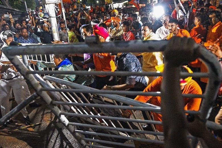 BJP supporters facing off Indian police amid clashes between rival groups during a campaign rally event held by BJP president Amit Shah in Kolkata on Tuesday. Fifty-nine people were arrested in the street battles.