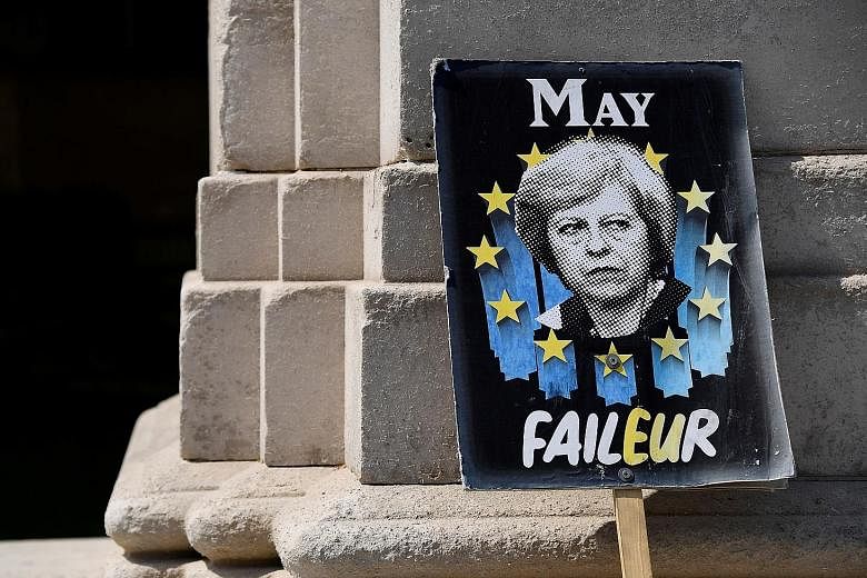 An anti-Brexit placard depicting British Prime Minister Theresa May near the Houses of Parliament in London yesterday. PHOTO: REUTERS