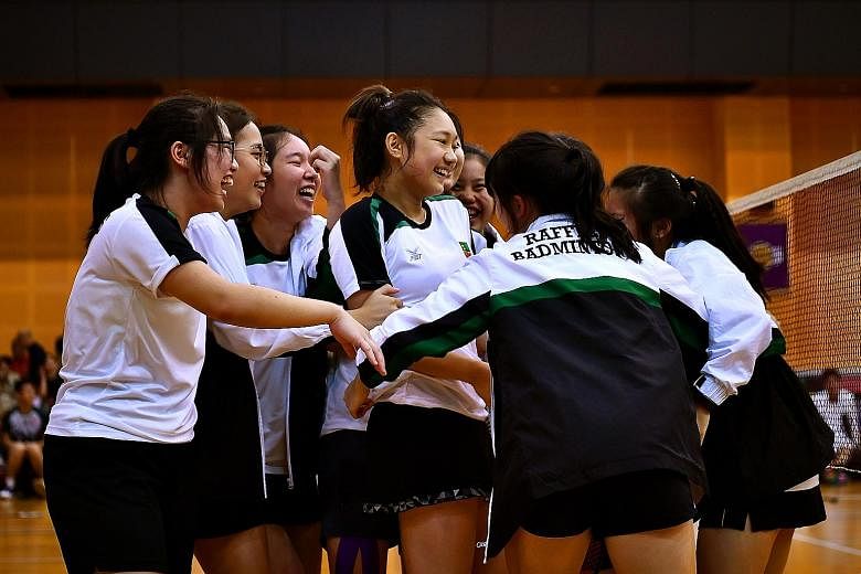 The RI A Division badminton girls celebrating after securing their winning point in the second doubles against HCI yesterday. ST PHOTO: LIM YAOHUI