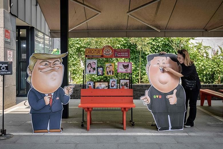 Caricatures of US President Donald Trump (left) and North Korean leader Kim Jong Un outside a shop in Seoul yesterday. Mr Trump and South Korea's Mr Moon Jae-in will discuss efforts to denuclearise the North.