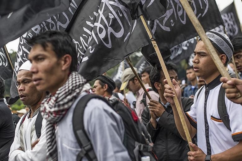 Indonesian Muslims waving the Hizbut Tahrir flag during an anti-government rally in Jakarta in July 2017, to condemn a decree banning groups that oppose Indonesia's official state ideology. The decree was seen as targeting radical Islamists in the co