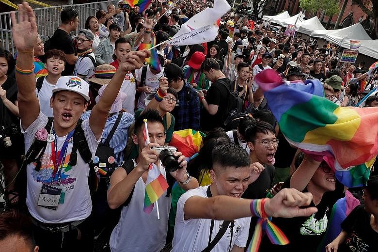 Supporters of same-sex marriage gathering outside the Parliament building in Taipei yesterday as a Bill for marriage equality was debated by parliamentarians. Lawmakers comfortably passed the Bill allowing same-sex couples to form "exclusive permanen