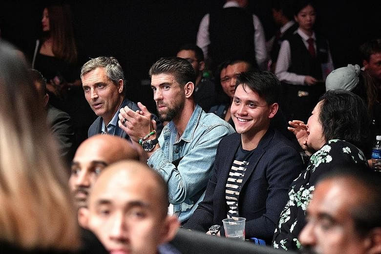 Michael Phelps seated next to Joseph Schooling watching One Championship's Enter the Dragon at the Singapore Indoor Stadium yesterday.