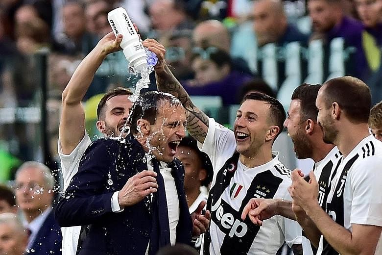 Coach Massimiliano Allegri celebrating Juventus' Serie A win with his players after beating Fiorentina 2-1 at home on April 20.