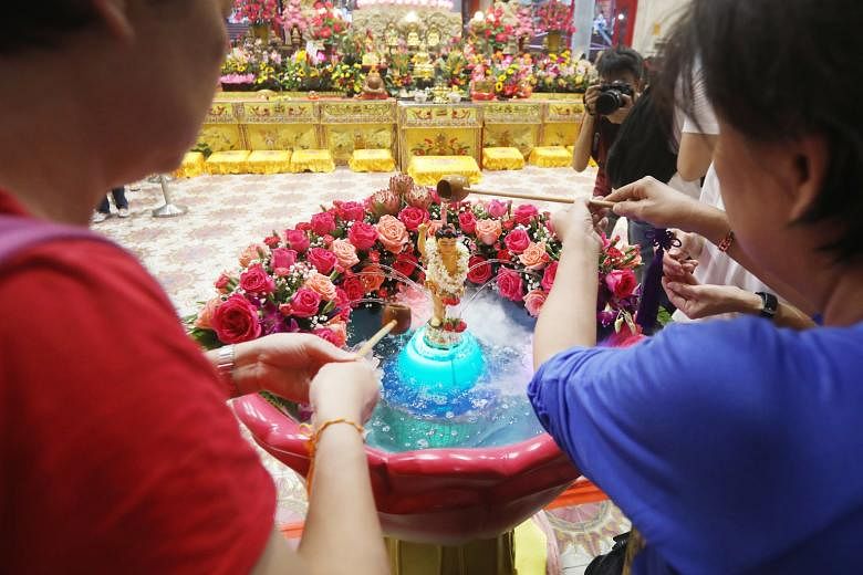 Devotees yesterday performed various rituals, such as "bathing the Buddha" in remembrance of his birth, at Kong Meng San Phor Kark See Monastery in Bright Hill Road, near Bishan, and the "three steps, one bow" rite at Bukit Gombak Stadium (left). In 