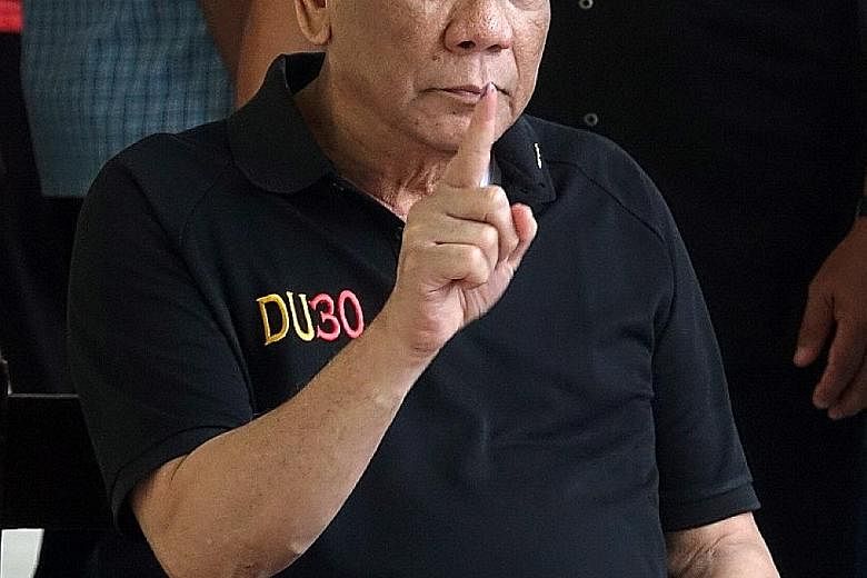 Philippine President Rodrigo Duterte showing the ink on his finger after casting his vote during the mid-term elections last week. His spokesman denied a media report that Mr Duterte had been in hospital since Friday. PHOTO: EPA-EFE
