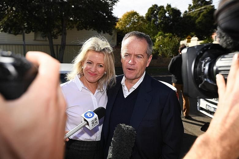 Mr Bill Shorten and his wife Chloe facing the media yesterday. The opposition Labor leader is stepping down after losing the election. PHOTO: DPA Australian Prime Minister Scott Morrison waving to the crowd at a rugby match in Sydney yesterday, a day