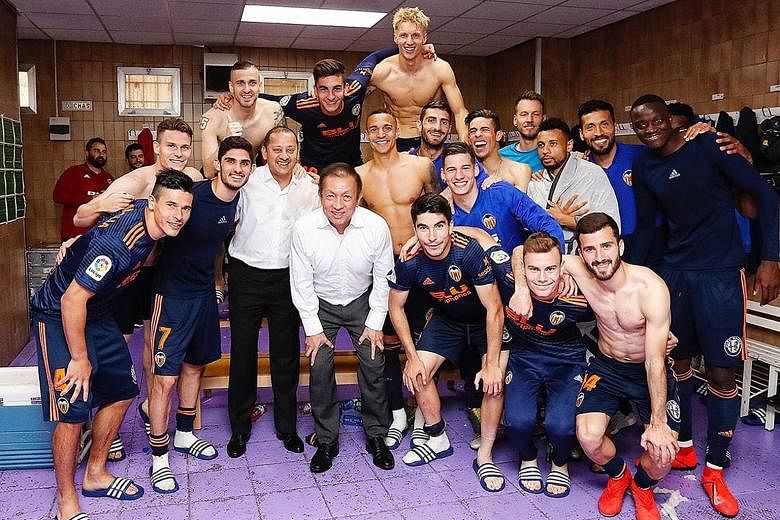 Singapore billionaire Peter Lim with Valencia players after their 2-0 win over Valladolid on Saturday to secure a spot in next season's Champions League - the third time since he bought the club five years ago. PHOTO: INSTAGRAM/VALENCIAFC