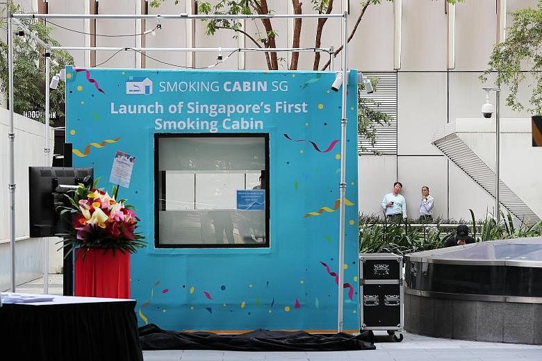 Singapore's first smoking cabin, which converts cigarette smoke into clean air, outside Fusionopolis in one-north, in Buona Vista. The cabin can fit up to 10 people at a time and utilises a three-layer filtration system.