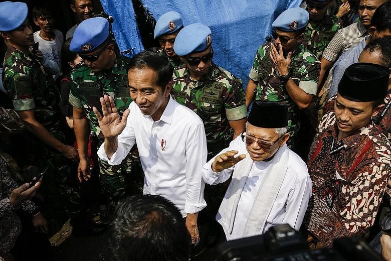 Above: Indonesian President Joko Widodo (left) and his running mate Ma'ruf Amin greeting residents after a victory speech in a Jakarta slum area yesterday. Right: Defeated presidential candidate Prabowo Subianto (at left) and his running mate Sandiag