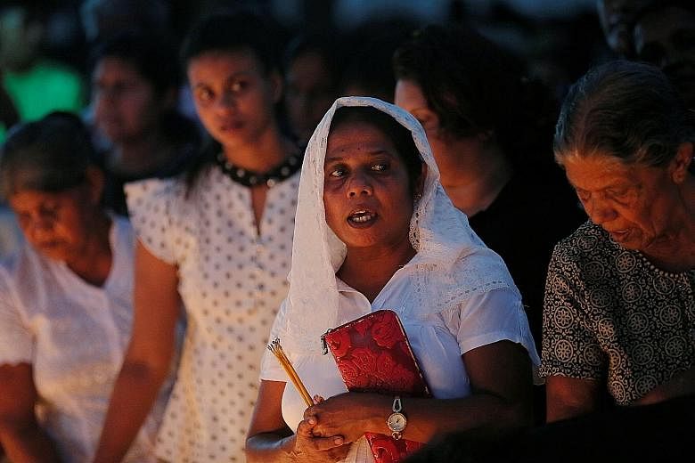 Devotees pray at a remembrance service for the bombing victims at St Sebastian church in Negombo, Sri Lanka, on Tuesday. PHOTO: REUTERS