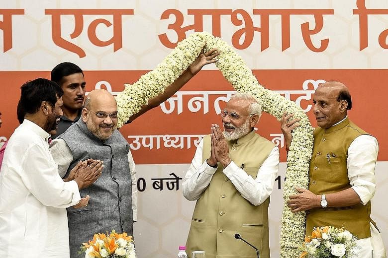 Bharatiya Janata Party (BJP) president Amit Shah (third from left) and Indian Prime Minister Narendra Modi (second from right) receiving a garland at a meeting in the BJP's New Delhi headquarters on Tuesday.