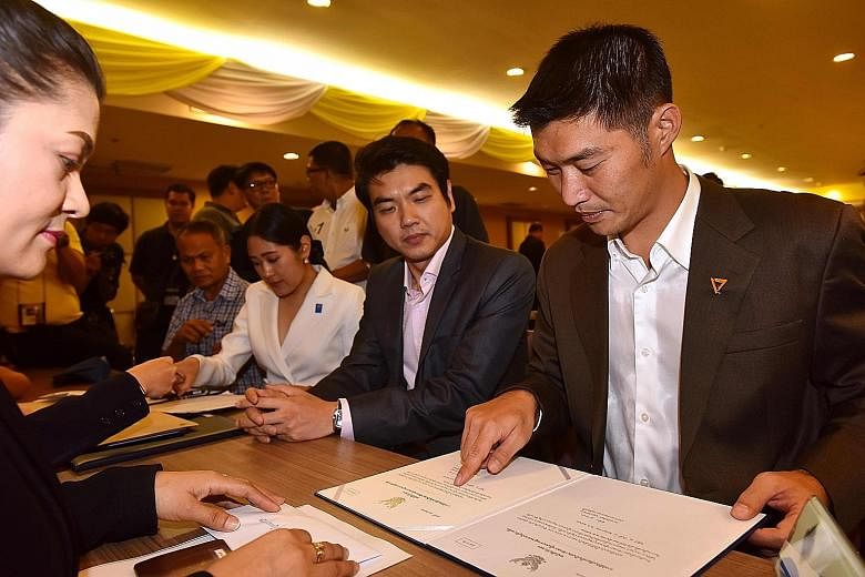 Future Forward Party leader Thanathorn Juangroongruangkit (right) and secretary-general Piyabutr Saengkanokkul (beside him) receiving the official certification as elected MPs in Bangkok earlier this month. PHOTO: AGENCE FRANCE-PRESSE