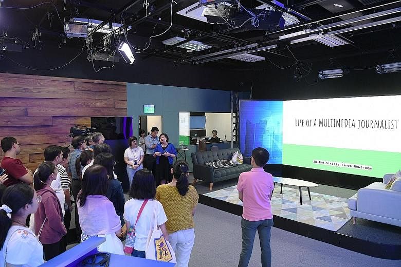 Straits Times subscribers watching a presentation on the life of a journalist by ST digital editor Ong Hwee Hwee (in blue cardigan) in the newsroom's new production studio yesterday.