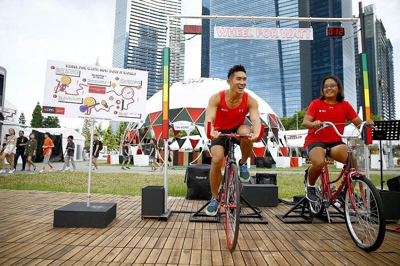 Kenneth Lee and Eveline Lau, captains of the DBS Asia Dragons men's and ladies' teams, cycling at the event's media preview yesterday. PHOTO: DBS