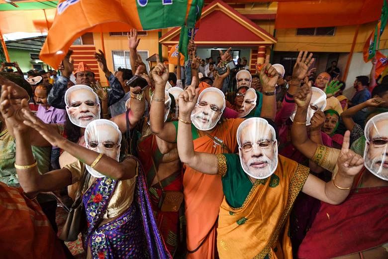 Supporters of the Bharatiya Janata Party (BJP), some wearing masks of Indian Prime Minister Narendra Modi, celebrating the decisive mandate won by their party on Thursday at the BJP office in Guwahati.