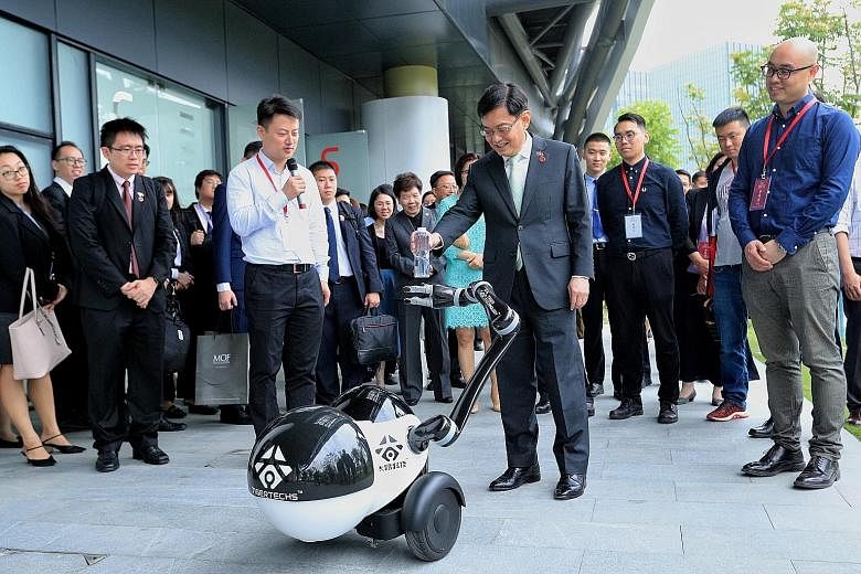 Deputy Prime Minister Heng Swee Keat interacting with a robot yesterday while on a tour of the Zhangjiang International Innovation Harbour, an artificial intelligence hub in Shanghai.
