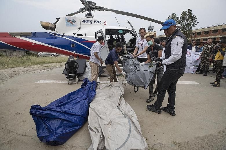 Nepalese trekking staff and policemen unloading the bodies of four unidentified climbers at a helipad of a hospital in Kathmandu last week. These were the bodies of climbers who died on Mount Everest in previous years and were found this year. The cl