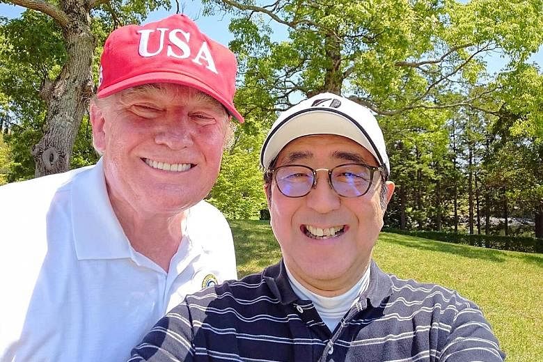 Mr Trump and Mr Abe taking a selfie at Mobara Country Club in Japan's Chiba prefecture yesterday. Mr Abe said he hoped to make the Japan-US alliance "even more unshakeable". US President Donald Trump and First Lady Melania Trump, flanked by Japanese 