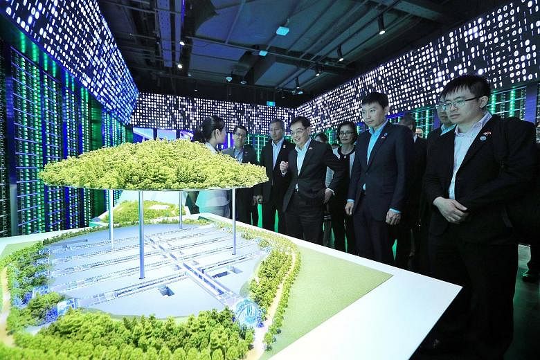 Deputy Prime Minister Heng Swee Keat (centre) viewing a model of Tencent's data centre in Guizhou during a tour of the Chinese technology giant's headquarters in Shenzhen yesterday. With him are (from right) Senior Minister of State for Trade and Ind