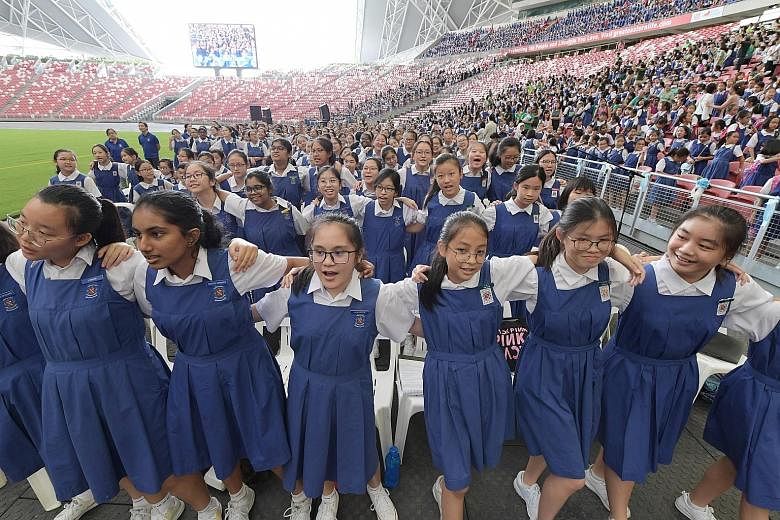 CHIJ schools celebrating their 165th anniversary at the National Stadium yesterday. The event drew 18,000 students, past and present, and included a thanksgiving mass led by Archbishop William Goh. ST PHOTOS: ALPHONSUS CHERN