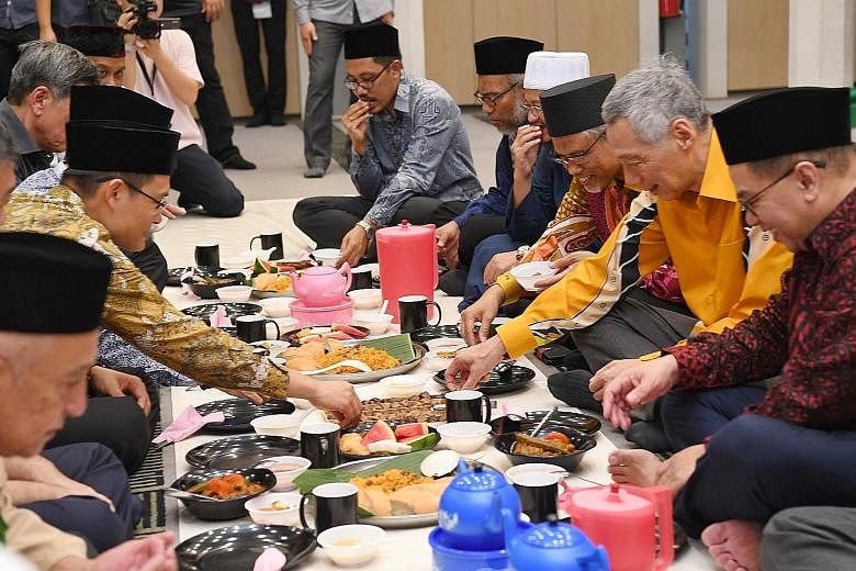 Prime Minister Lee Hsien Loong at the break-fast session at Masjid Alkaff Upper Serangoon. He was flanked by the mosque's executive chairman Kassim Kamis (right) and Minister-in-charge of Muslim Affairs Masagos Zulkifli. Muis chief executive Esa Maso