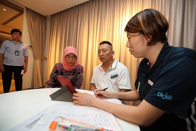 Mr Mohamad Zahir, 27, who has a form of muscular dystrophy, flanked by physiotherapists Emily Ang and Mary Wrixton as he worked on his rehabilitation exercises.