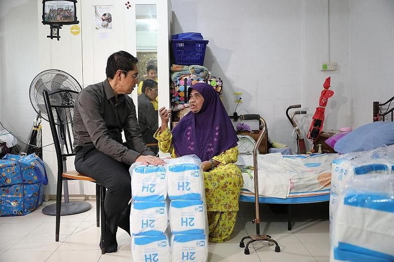 Dr Maliki Osman, Senior Minister of State for Defence and Foreign Affairs, visiting Madam Maimunah Hussin, 72, at her home in Bedok yesterday. Madam Maimunah is one of 500 beneficiaries in the South East District who received adult diapers through Pr