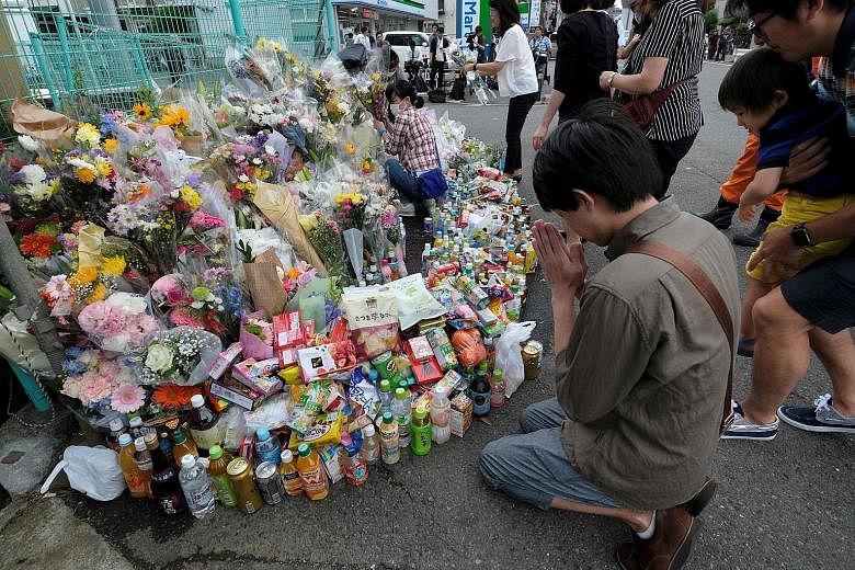 A man praying yesterday at the scene of the attack, where flowers and other tributes to those killed were laid. The rampage on Tuesday morning killed two people and injured 17 others, mainly young children. The 51-year-old attacker died after stabbin
