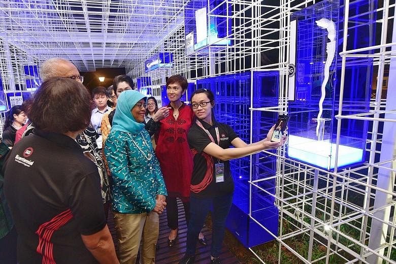 President Halimah Yacob, her husband Mohamed Abdullah Alhabshee and Manpower Minister Josephine Teo (in red), looking at a 3D-printed giant replica of a keris from 19th-century Palembang in South Sumatra. They were touring the Emporium of the East pa