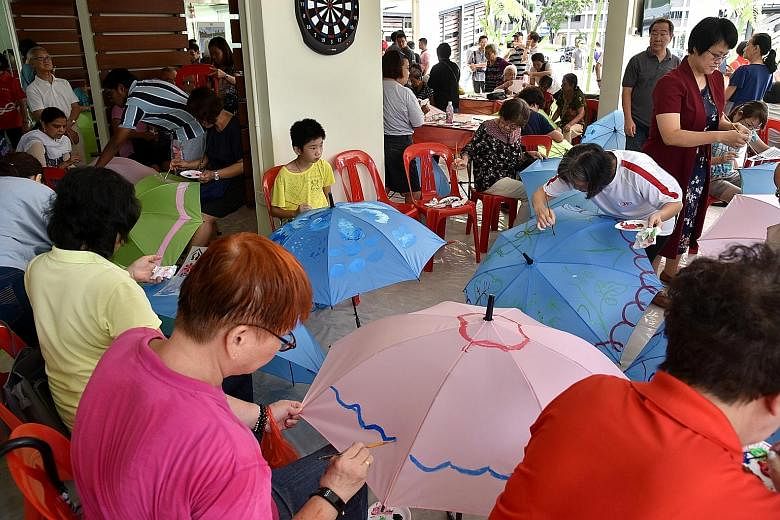 Participants painting umbrellas at a workshop held by Cheng San-Seletar Grassroots Organisations and Touch Community Services at the hub yesterday. 