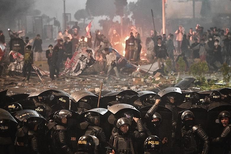 Indonesian police taking a barrage of rocks, fireworks, Molotov cocktails and other projectiles from rioters during a riot outside election supervisory agency Bawaslu's headquarters in downtown Jakarta on May 22. The violence peaked in the evening th