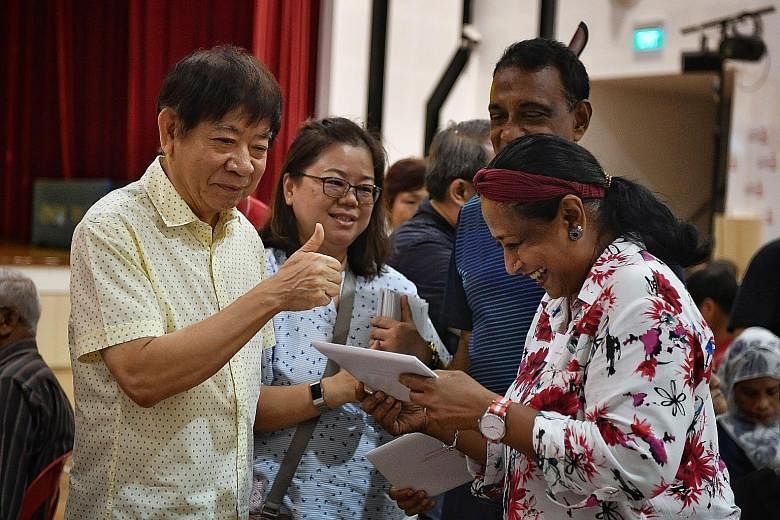 Transport Minister Khaw Boon Wan giving a resident her Merdeka Generation Package at ACE The Place Community Club in Woodlands yesterday, where 250 Sembawang GRC residents received their packages. ST PHOTO: CHONG JUN LIANG Home Affairs and Law Minist