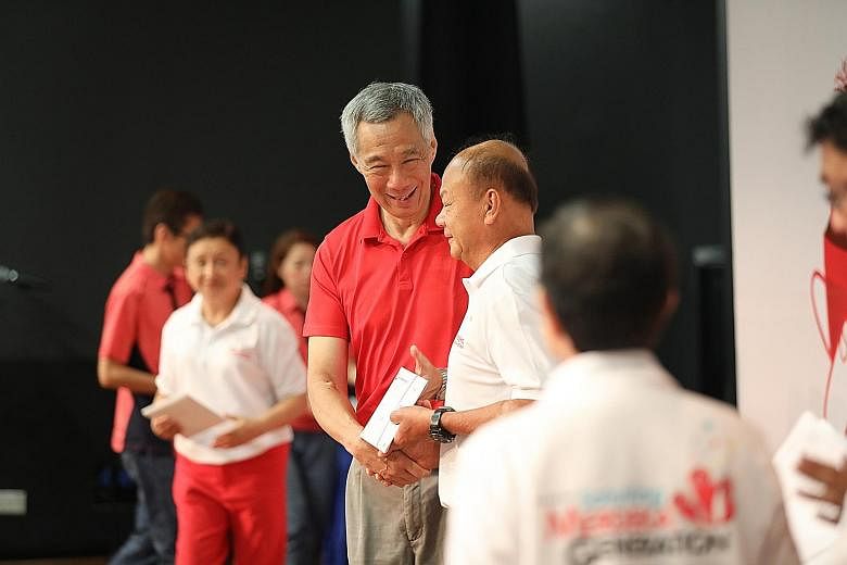 Prime Minister Lee Hsien Loong presenting welcome folders to members of the Merdeka Generation at an appreciation ceremony at the Institute of Technical Education College Central yesterday. ST PHOTO: ONG WEE JIN