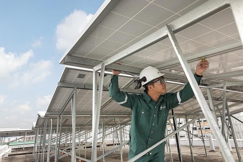 A Sembcorp Solar worker inspecting panels at one of Sembcorp's HDB rooftop project sites in Choa Chu Kang. Besides hiring contractors, Sembcorp employs about 35 workers in its solar team.