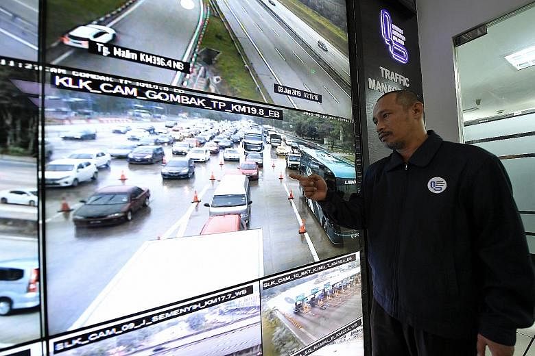 Malaysian Highway Authority officer Kamarudin Moktah showing the slow flow of traffic from a CCTV at the Gombak toll booth yesterday, two days before Hari Raya. The highway links the Malaysian capital Kuala Lumpur to the east coast states of Pahang, 