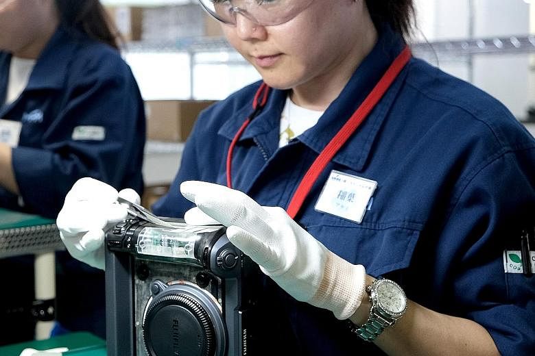 A technician putting the finishing touches to Fujifilm's latest medium-format mirrorless camera GFX 100 at Fujifilm's factory in Taiwa, Japan.