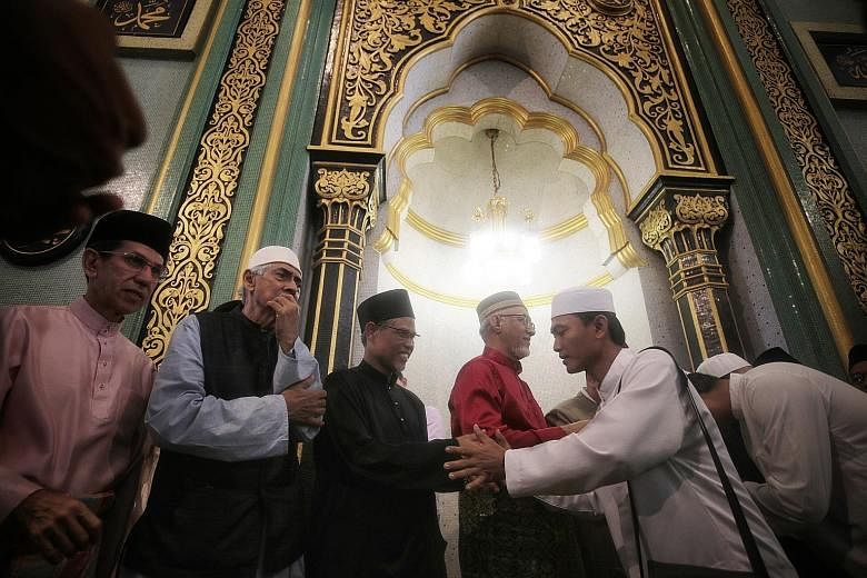 Minister-in-charge of Muslim Affairs Masagos Zulkifli (third from left) greeting congregants together with (from left) Islamic Religious Council of Singapore president Mohammad Alami Musa, the mosque's chairman Mohamed Salleh Patail, and Mr Mohamed A
