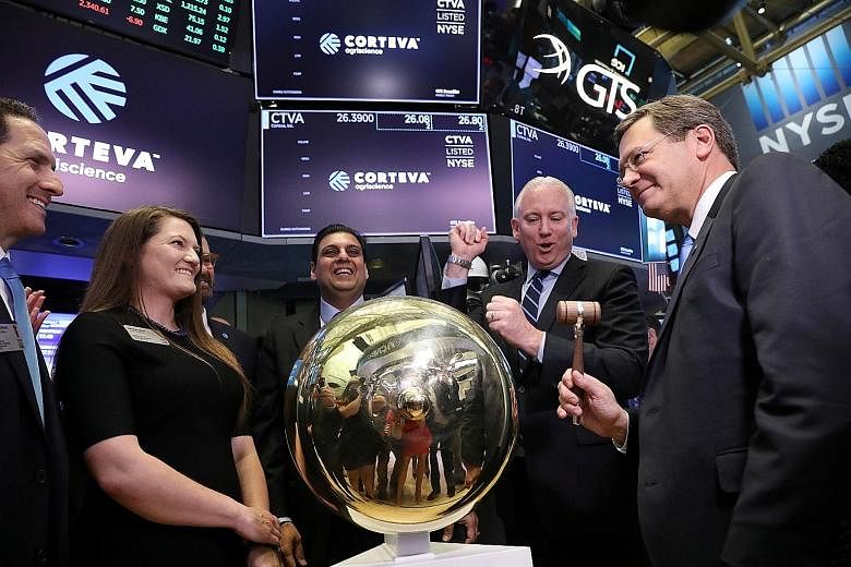 Corteva Agriscience chief executive Jim Collins (right) ringing a ceremonial bell to begin trading on the floor of the New York Stock Exchange on Monday. PHOTO: REUTERS
