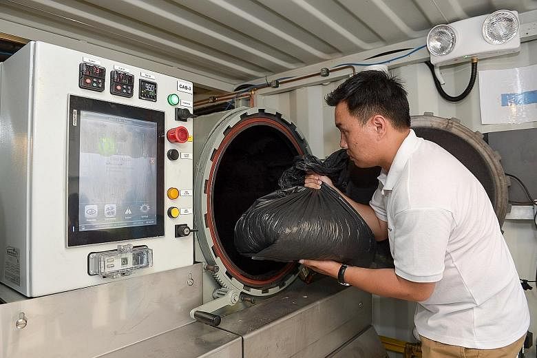 Mr Dex Ng, assistant director for conservation and environmental sustainability at Gardens by the Bay, demonstrating the disposal of trash into the gasification system. The system, created by SP Group, began operating last month and will run as a pil