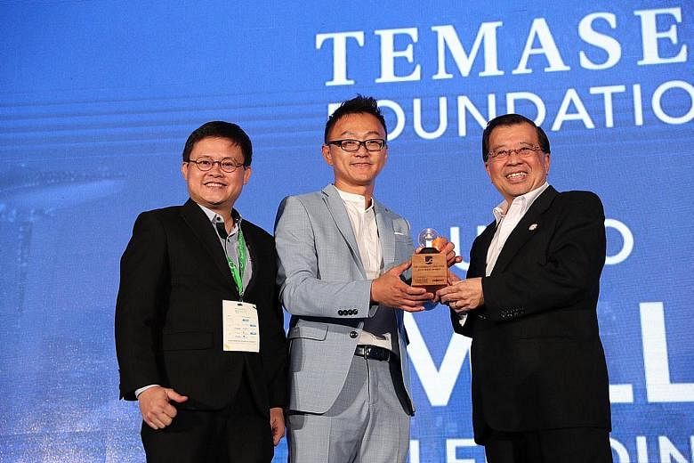 (From far left) Sophie's Kitchen co-founder and chief operating officer Barnabas Chan and founder and chief executive Eugene Wang receiving the award from Temasek Foundation Ecosperity CEO Lim Hock Chan at the Sands Expo and Convention Centre at Mari