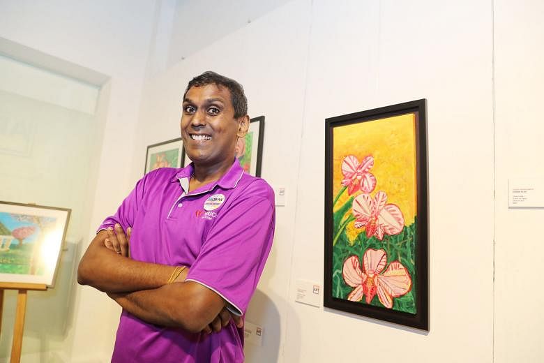 Above: Touch Centre for Independent Living beneficiary Shoban Pillai with his artwork, Local Flower Orchids, at Touch Giving Art, a charity art exhibition at The Arts House, yesterday. Left: Guests viewing the artworks at the exhibition yesterday.