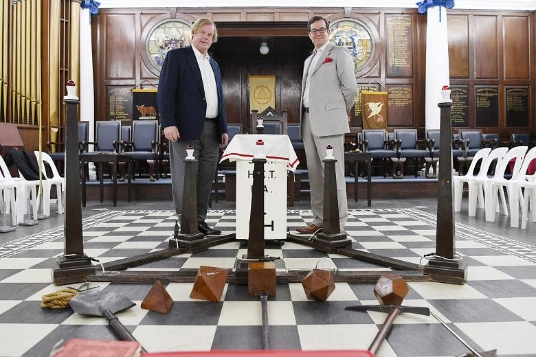 Sir David Wootton (far left), assistant grand master of the United Grand Lodge of England, with its grand secretary, Dr David Staples, in the main temple of the Freemasons' Hall in Singapore yesterday. They are in Singapore for the assembly of the Di