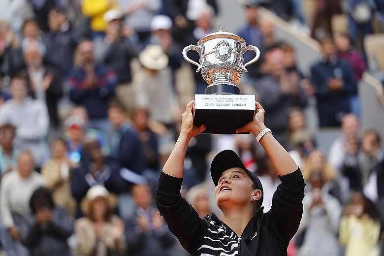 Australia's Ashleigh Barty lifting the Suzanne Lenglen Cup after beating Czech Marketa Vondrousova 6-1, 6-3 in the French Open women's final yesterday. She is the third Australian woman to win the trophy. PHOTO: REUTERS