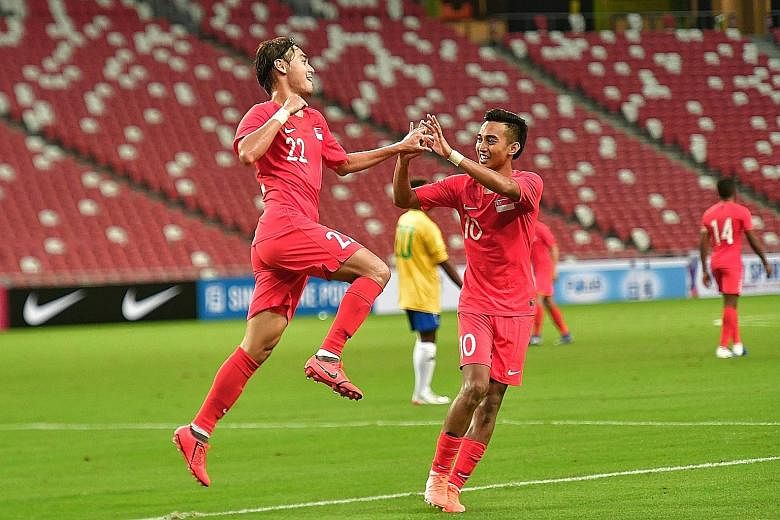 Singapore forward Gabriel Quak celebrating with Faris Ramli after he scored the Lions' third goal against the Solomon Islands in the friendly match at the National Stadium last night. Faris had scored the first goal in the fourth minute.