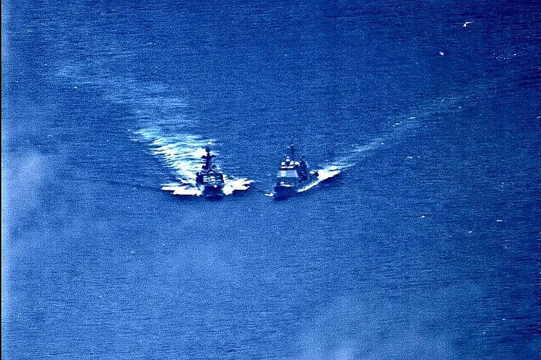 A surveillance photo showing the Russian naval destroyer (left) making what the US Navy described as an unsafe manoeuvre against guided-missile cruiser USS Chancellorsville in the Philippine Sea on Friday. PHOTO: REUTERS