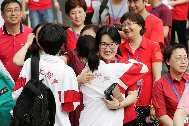 Teachers hugging students as they arrived for the first part of China's annual national college entrance exam in Beijing on Friday. Despite concerns among parents and students over strained US-China ties, experts say they do not expect the number of 