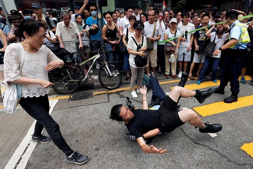 Above: A police officer and a protester getting into a scuffle. At least seven people were arrested along the protest route. Left and below: Demonstrators filling the streets yesterday to protest against changes to the extradition law. More than a mi