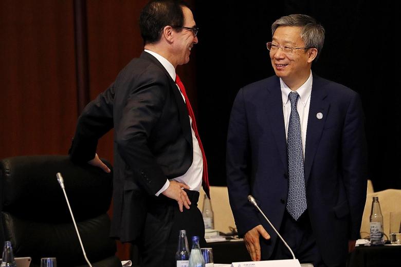 People's Bank of China governor Yi Gang with US Treasury Secretary Steven Mnuchin at a meeting of Group of 20 finance ministers and central bankers in Fukuoka on Saturday. Mr Mnuchin tweeted that they had a candid and constructive discussion.
