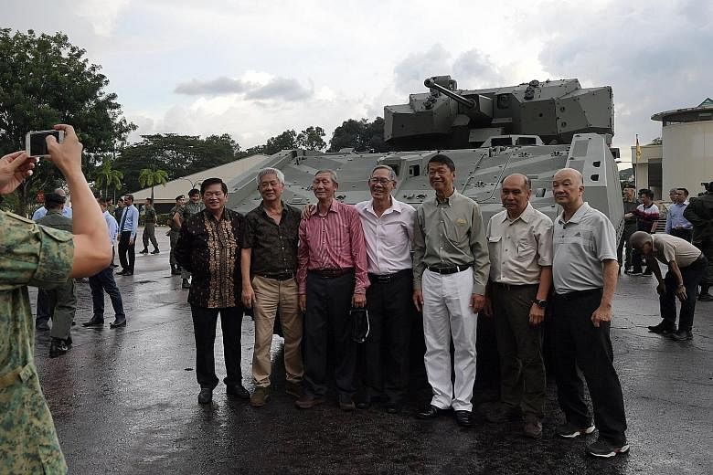 Former servicemen from the armour formation posing for photographs with the Hunter, the army's latest armoured fighting vehicle, at Sungei Gedong Camp yesterday. The vehicle is locally designed and developed by the DSTA with ST Engineering and the ar